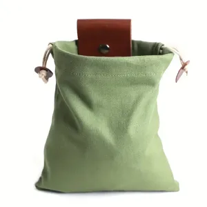 Canvas foraging pouch with drawstring and leather snap closure for outdoor camping fruit picking.