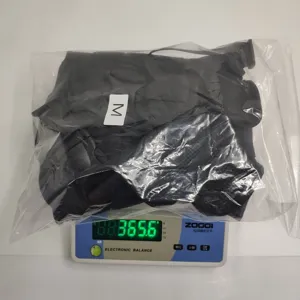 Tactical dog vest harness detail showing size M packaging and weight measurement on scale.