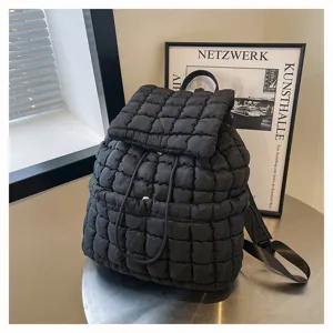 Detail view of a black quilted puffer backpack featuring a trendy wrinkled design and soft texture.