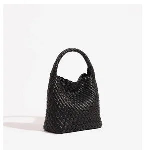 Black woven leather handbag detail shot showing exquisite intrecciato craftsmanship texture.