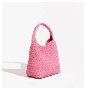 Pink woven leather handbag detail, soft material and stylish knot handle design.