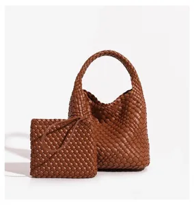Close-up view of brown leather woven handbag and pouch highlighting detailed texture and fine craft.