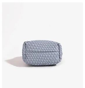 Close-up detail view of light blue woven leather handbag showcasing exquisite leathercraft.