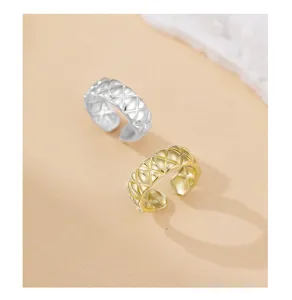 Primer plano detallado del anillo abierto con exquisito patrón de rombos en plata y oro.
