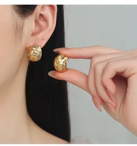 Detailed close-up shot of gold textured woven C-hoop earrings worn gracefully on the ear.