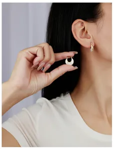 Gros plan detaille sur ces elegantes boucles d'oreilles nacrees en U pour look chic.