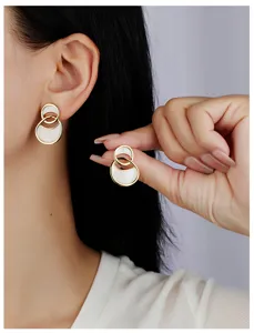 Primer plano de pendientes dobles estilo francés con esmalte blanco y diseño elegante.