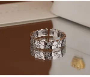 Élégante bague ouverte en argent sterling avec design alvéolé et zircons étincelants.