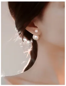 Close-up detail of elegant double-sided pearl earrings featuring chic back-and-front design.