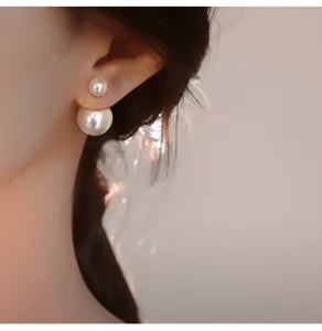 Detail view of elegant double-sided pearl stud earrings featuring a chic minimalist design.