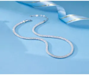 Close-up view of sparkling silver mesh necklace showing delicate texture and chain detail.