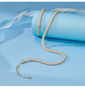 Exquisite gold tubular mesh necklace detail, luxury chic choker jewelry display close up shot.