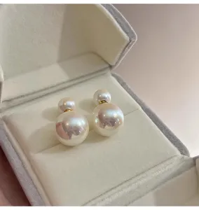 Detailed shot of double pearl earrings in a grey velvet box, showcasing elegant design.