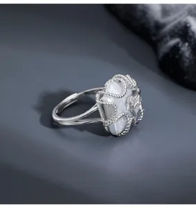 Detailed view of a 925 sterling silver geometric baroque pearl open ring with twisted frame.