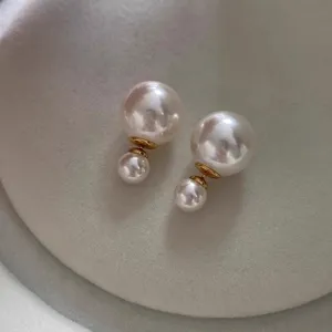 Elegant double-sided pearl stud earrings featuring large and small pearls for a chic versatile look.
