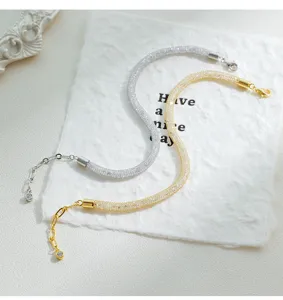 Elegantes pulseras tubulares de cristal brillante en tonos plata y oro con extensión.