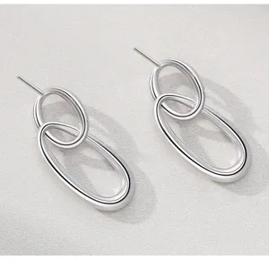 Gedetailleerd overzicht van elegante geometrische ineengestreepte zilveren oorbellen voor dames.