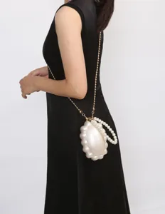 Detail shot of the pearl shell evening bag showcasing the exquisite chain and handle design.