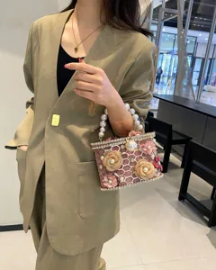 Elegante borsa rigida con strass e manico di perle, dettagli floreali, pochette chic.