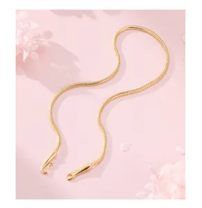 Detail shot of a minimalist gold round snake bone chain necklace with special hook clasp.