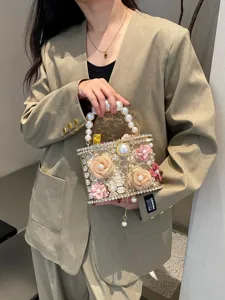 Borsa da sera di lusso con perle e strass, borsa rigida in metallo traforato con fiori.