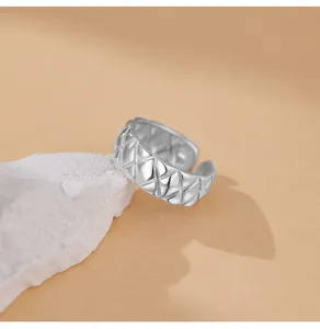 Primer plano detallado de un clásico anillo abierto acolchado de plata con diseño exquisito.