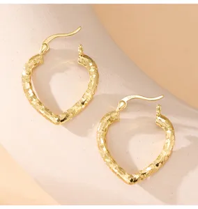 Vue détaillée de boucles d'oreilles cœur en argent S925, finition bijouterie CNC raffinée.