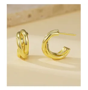 Gedetailleerd overzicht van minimale dubbellaagse C-vormige geometrische gouden oorbellen.