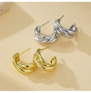 Gedetailleerd overzicht van dubbellaagse c-vormige geometrische oorringen, metalen sieraden.