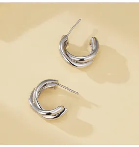 Gedetailleerd uitzicht op minimalistische dubbellaagse C-vormige zilveren oorknoppen chic.
