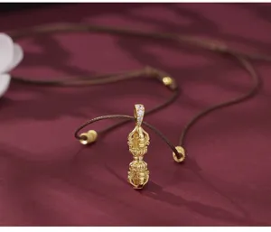 Exquisite S925 silver gold-plated Vajra pendant close-up, detailed craftsmanship and brown cord.