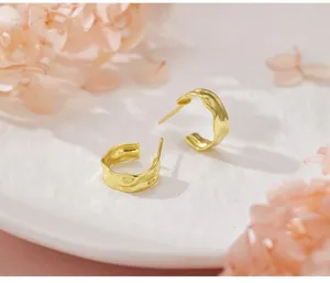 Détail de gros plan de boucles d'oreilles géométriques irrégulières, design froissé.