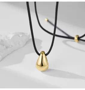 Collier pendentif goutte d'or minimaliste avec cordon noir réglable pour femmes élégantes.