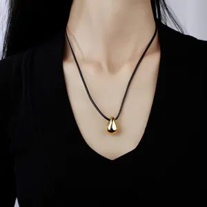 Elegant collier pendentif goutte dore avec cordon en cuir noir style minimalist chic