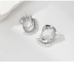 Gros plan sur les boucles d'oreilles pendantes en métal argenté avec des perles cristal.