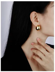 Glossy gold teardrop C-shape hoop earrings for women, minimalist chic copper jewelry detail.