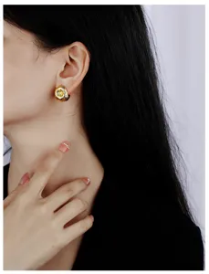 Detalle de pendientes de cobre chapado en oro con acabado cepillado de diseño único.