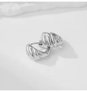 Silver metal geometric croissant hoop earrings detail, minimalist niche design for women.