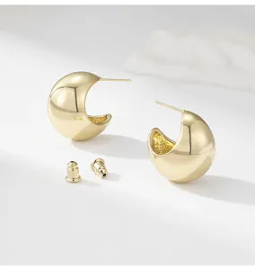 Detailed close-up of chunky gold C-shaped hoop earrings with secure backings for stylish look.