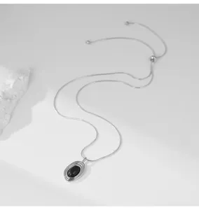 Collier long réglable pour femmes avec pendentif en pierre ovale noire, style élégant.