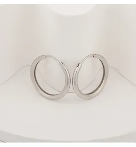 Close-up detail view of elegant silver hoop earrings with a chic brushed texture finish.