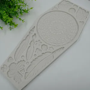 Detalle de molde de silueta de silicona con patrones de atrapasueños y plumas para repostería.