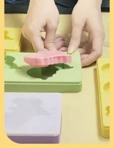 Detail view showing hands demonstrating the silicone ice cream mold in use, highlighting flexibility.