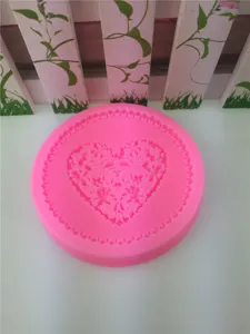 Close up view of pink silicone mold featuring heart floral lace relief texture for DIY craft making.