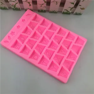 Detailed view of the pink silicone mold showing clear letter and flower cavity engravings.