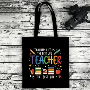 Black canvas tote bag with colorful teacher letter print, casual eco-friendly shoulder bag.