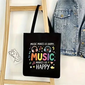 Vista detallada de un bolso de lona negro con estampado musical colorido y asas muy resistentes.