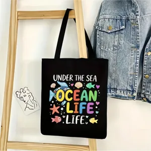 Vista detallada del bolso de lona negro con estampado marino colgado en escalera de madera.