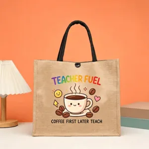 Close-up detail of teacher jute tote bag with cute coffee cup print and sturdy black handles.