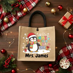 Christmas teacher burlap tote bag detailed shot showing cute penguin print and custom name.